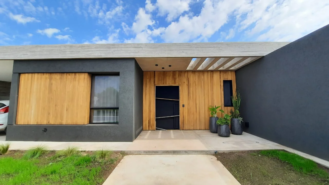 Casa Lucrecia Pilar — entrada principal con revestimiento de madera